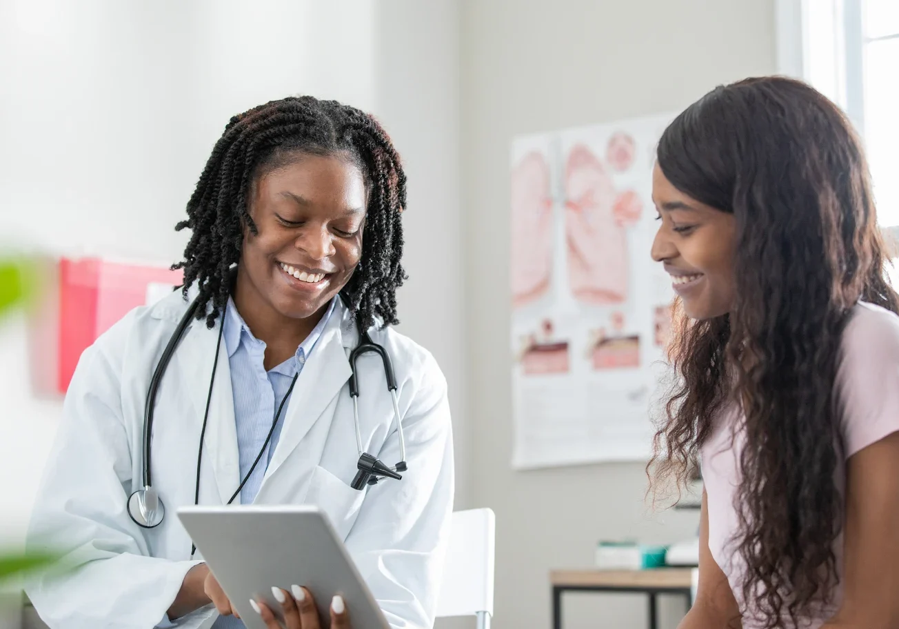 Doctor consulting a patient with a digital tablet in a medical office.