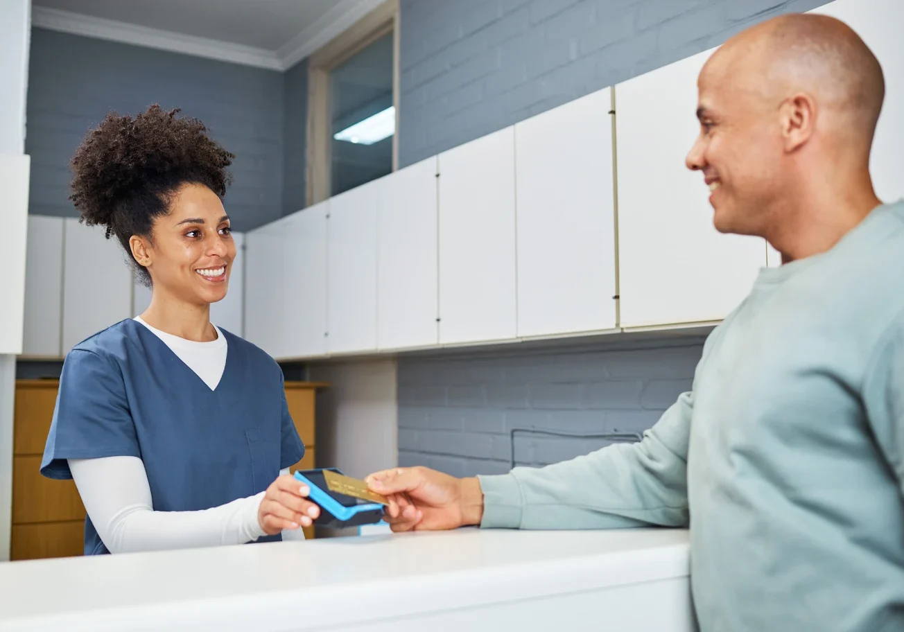 A man paying with a credit card at a reception desk.