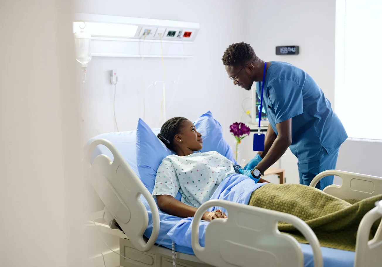 A nurse comforting a patient in a hospital bed.